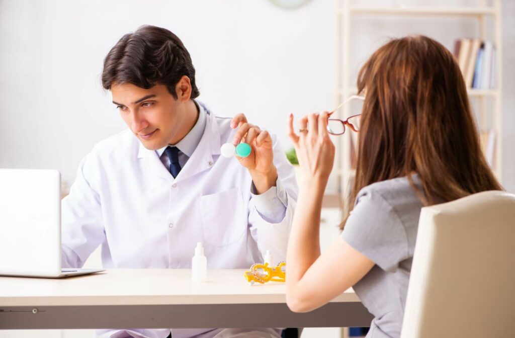 An optometrist explains the importance of proper contact lens wear and care to their patient during their annual contact lens fitting.