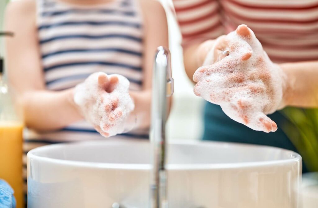  A parent and their child thoroughly wash their hands to prevent the spread of germs.
