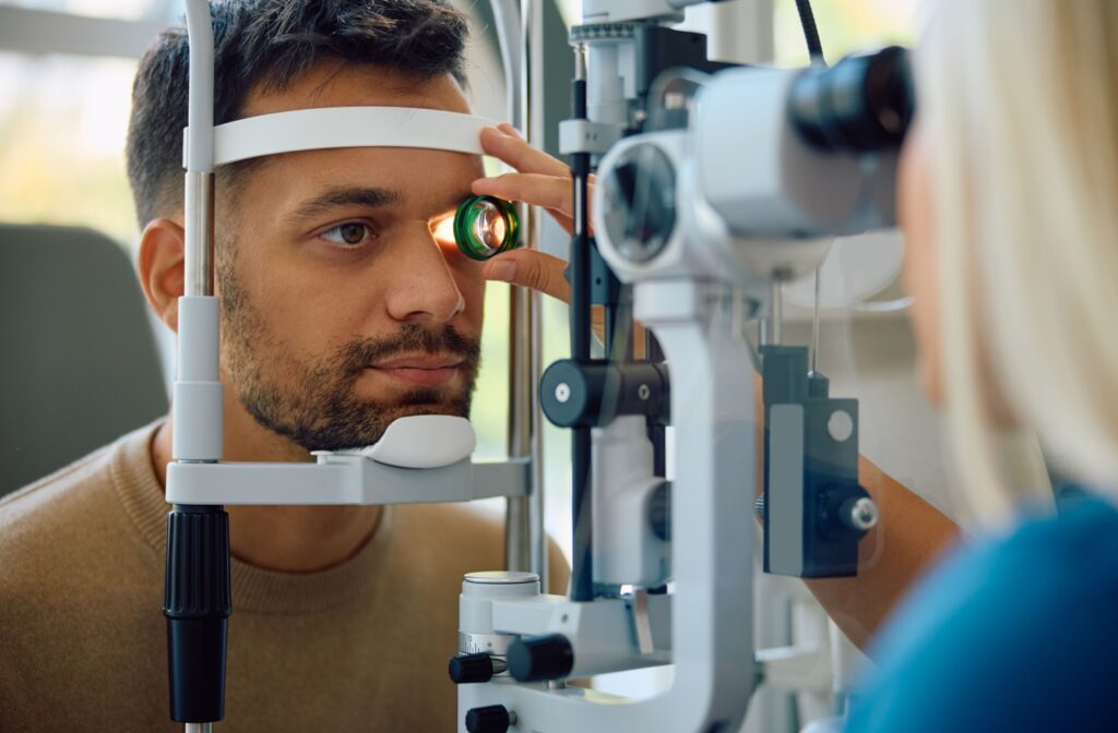 An eye doctor using a magnifying lens to get a closer look at their patient's eye during a comprehensive eye exam