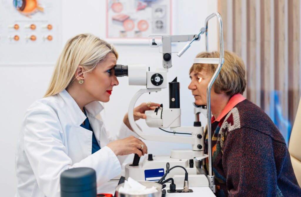 An optometrist examines their patient's eyes using a slit-lamp during an eye exam.