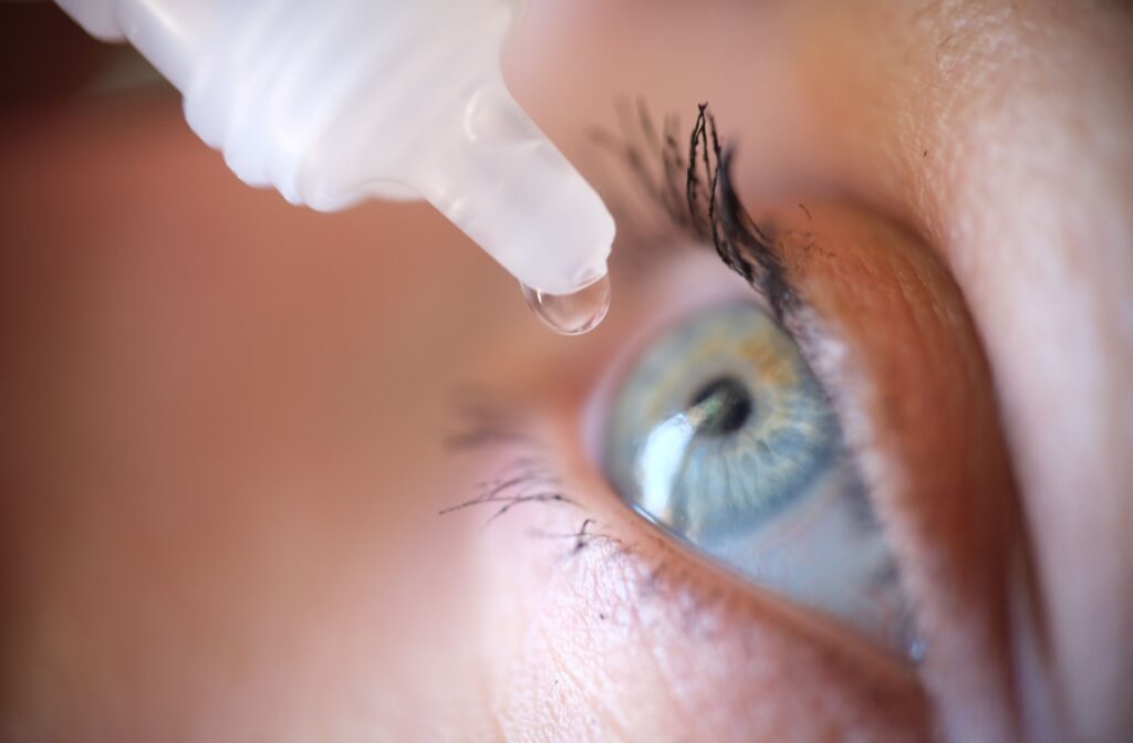 Close up of blue eye with eye drop going into it.